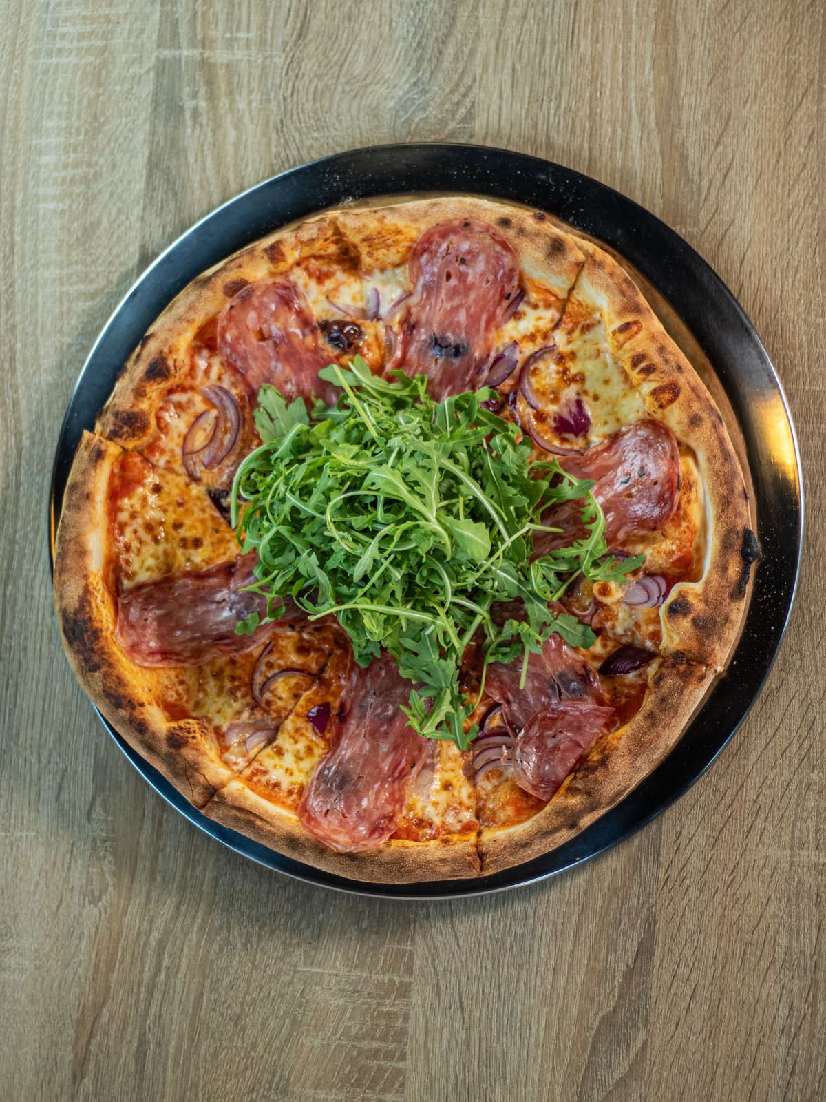 Pizza Truffa: San Marzano, fior di latte, salami spinata z truflą, oliwki Riviera, czerwona cebula, rukola